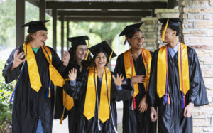 a group of graduation graduates walking down an outside walk way