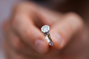 young man giving engagement ring to his girlfriend. Man making marriage proposal to his beloved woman. Romantic date
